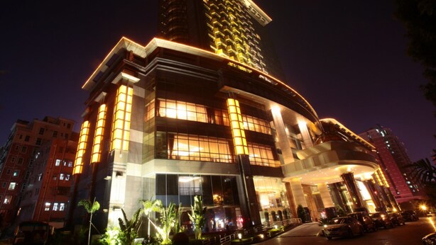 A modern hotel with a prominent tower, multiple floors, and a well-lit facade. - Asta Hotel (Shenzhen)