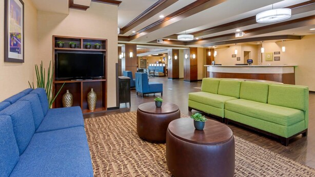 A hotel lobby with a blue sofa, green sofa, and a reception desk. - Comfort Suites Little Rock West (Little Rock)