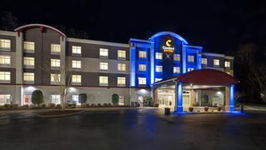 A hotel with a prominent 'Comfort Suites' sign, a covered entrance, and a well-lit facade. - Comfort Suites Williamsburg Historic Area (Williamsburg)