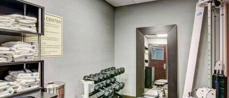 A gym with weight racks, benches, and exercise equipment.