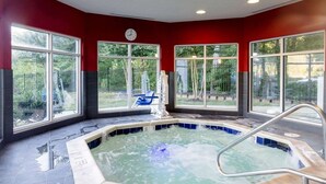 A hot tub with a metal ladder, surrounded by large windows with a view of greenery. - Comfort Suites Williamsburg Historic Area (Williamsburg)