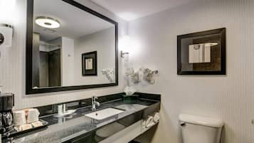 Een moderne badkamer met een grote spiegel, een wastafel en een toilet.