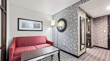 Um lobby moderno com piso estampado, um sofá vermelho, uma mesa de centro, uma moldura com imagem e um espelho fixado na parede.