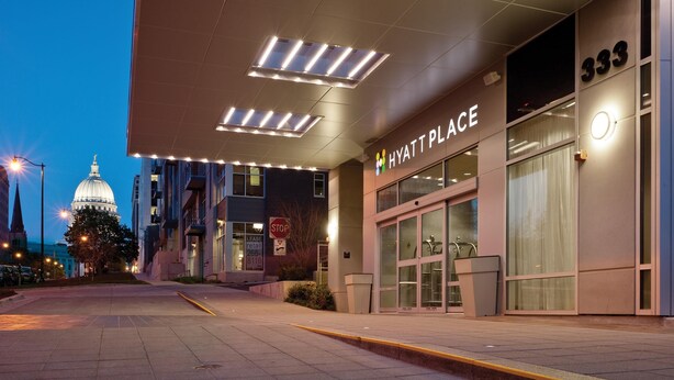L’entrée d’un hôtel au design moderne, avec un éclairage attrayant et une vue dégagée sur la rue.