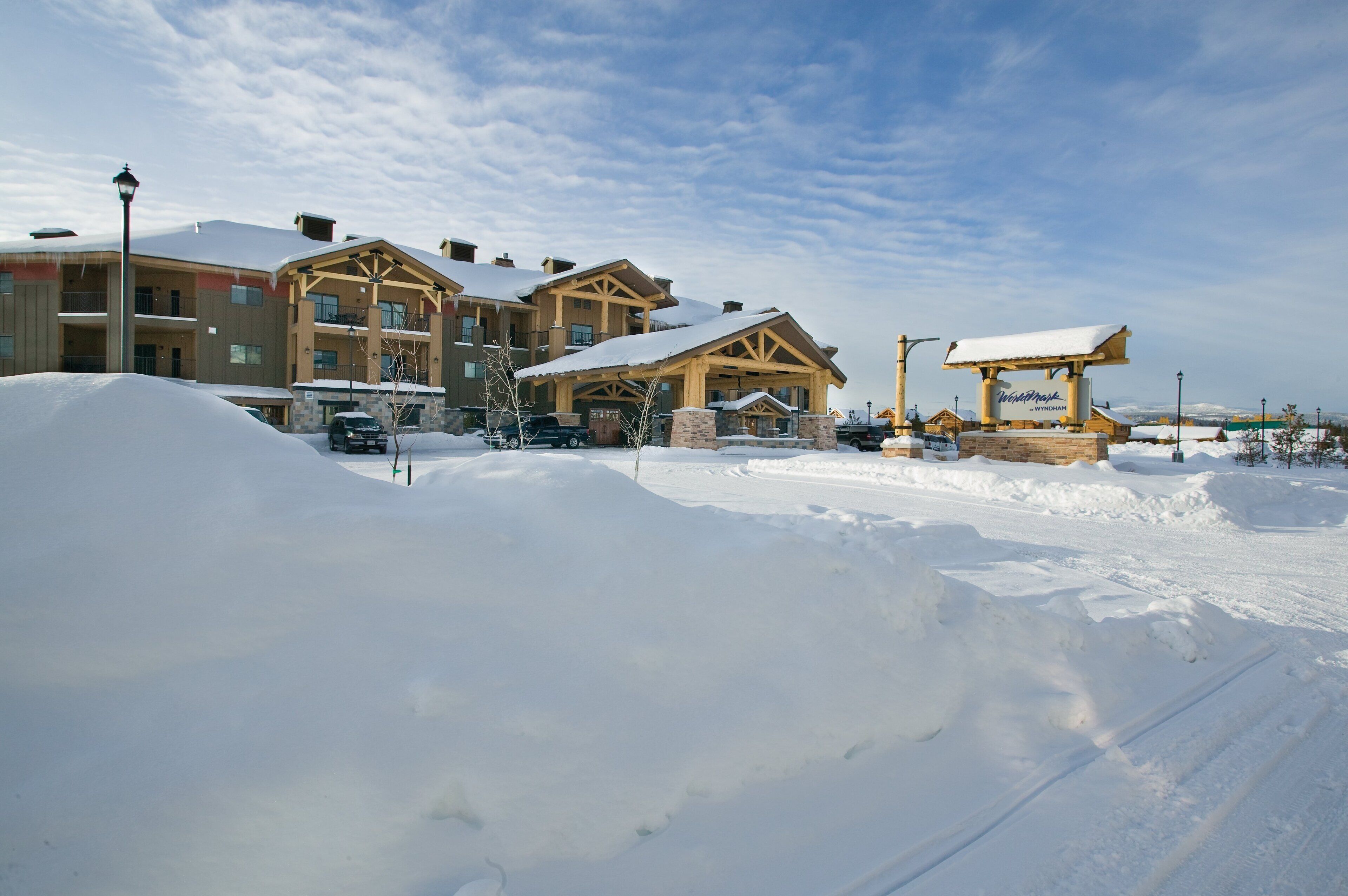 A snow-covered building with a wooden facade and multiple balconies.