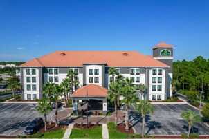 Ein Hotel mit rotem Ziegeldach, mehreren Etagen und einem zentralen Eingangsbereich mit Vordach.