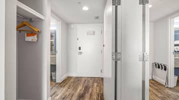 Un couloir doté d’un plancher en bois, de murs blancs et d’une porte sur laquelle figure un panneau indiquant les consignes de sécurité incendie.