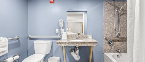 Un baño con inodoro, lavamanos, ducha y secador de manos.