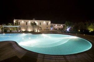 Una piscina cubierta, sombrillas, tumbonas