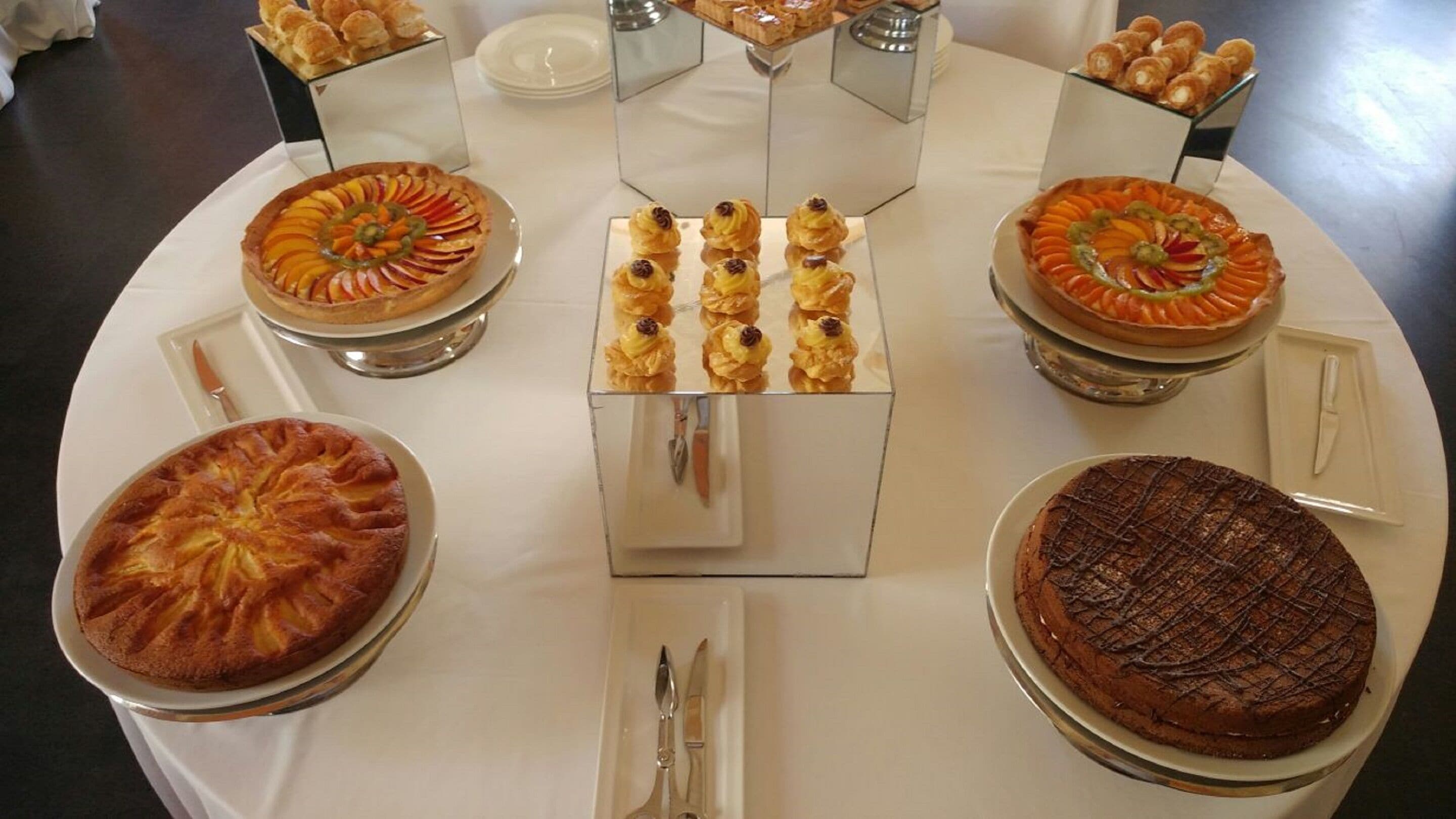 A dessert buffet with various cakes and pastries arranged on a table.