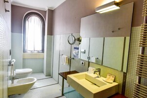Un baño con inodoro, bidé, lavabo y espejo.