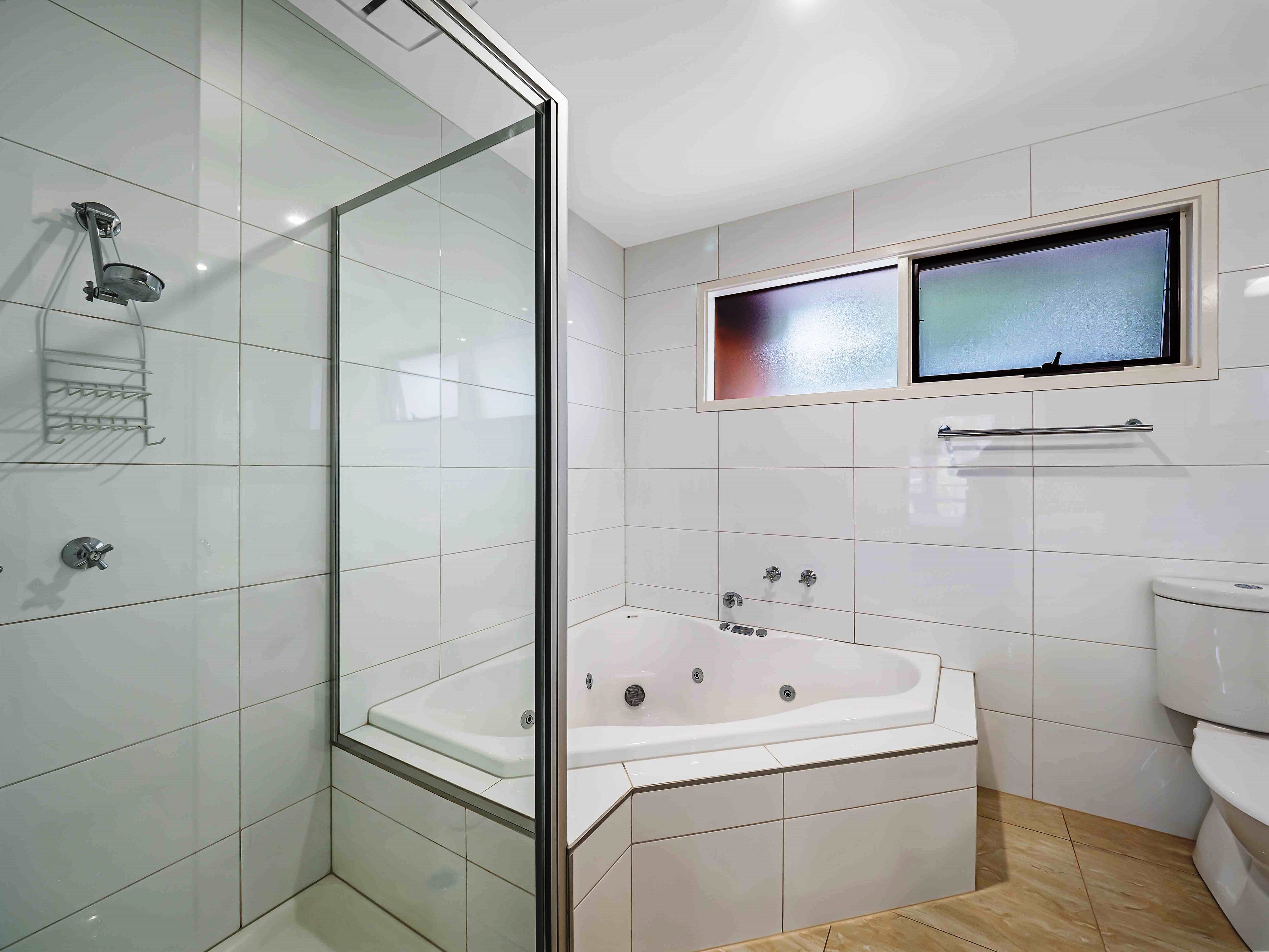 Une salle de bain moderne avec une douche à parois de verre, une baignoire sur pieds et des toilettes.