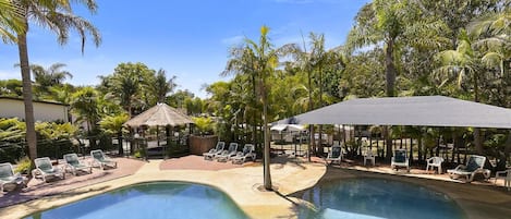Piscine extérieure en saison, chaises longues
