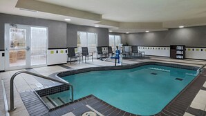 An indoor swimming pool with a tiled floor, a pool ladder, and a few chairs around the pool area. - Fairfield Inn & Suites Tulsa South Medical District (Tulsa)