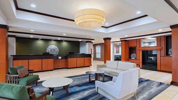 A hotel lobby with a reception desk, seating area, and kitchen. - Fairfield Inn & Suites Tulsa South Medical District (Tulsa)