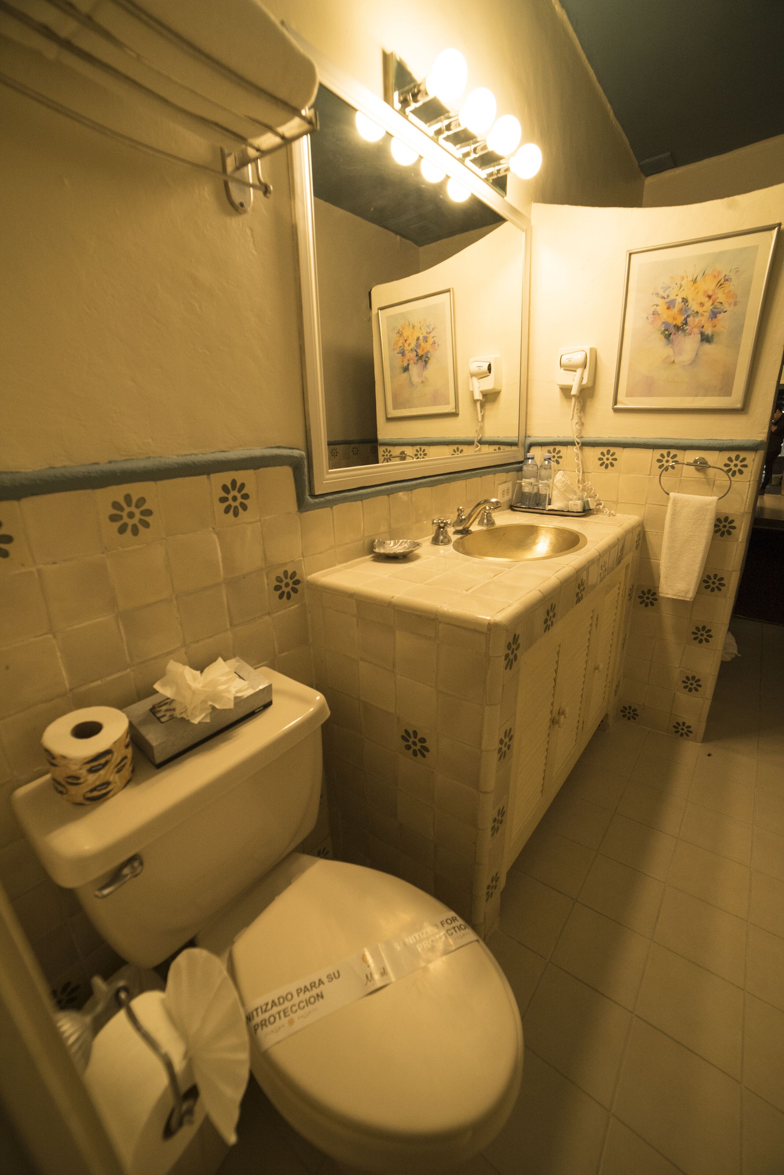 Un baño con inodoro, lavamanos y espejo.