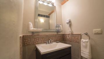 A bathroom with a sink, mirror, and hairdryer.