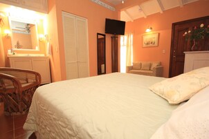 Un dormitorio con una cama grande, un armario de madera, un televisor y una silla.