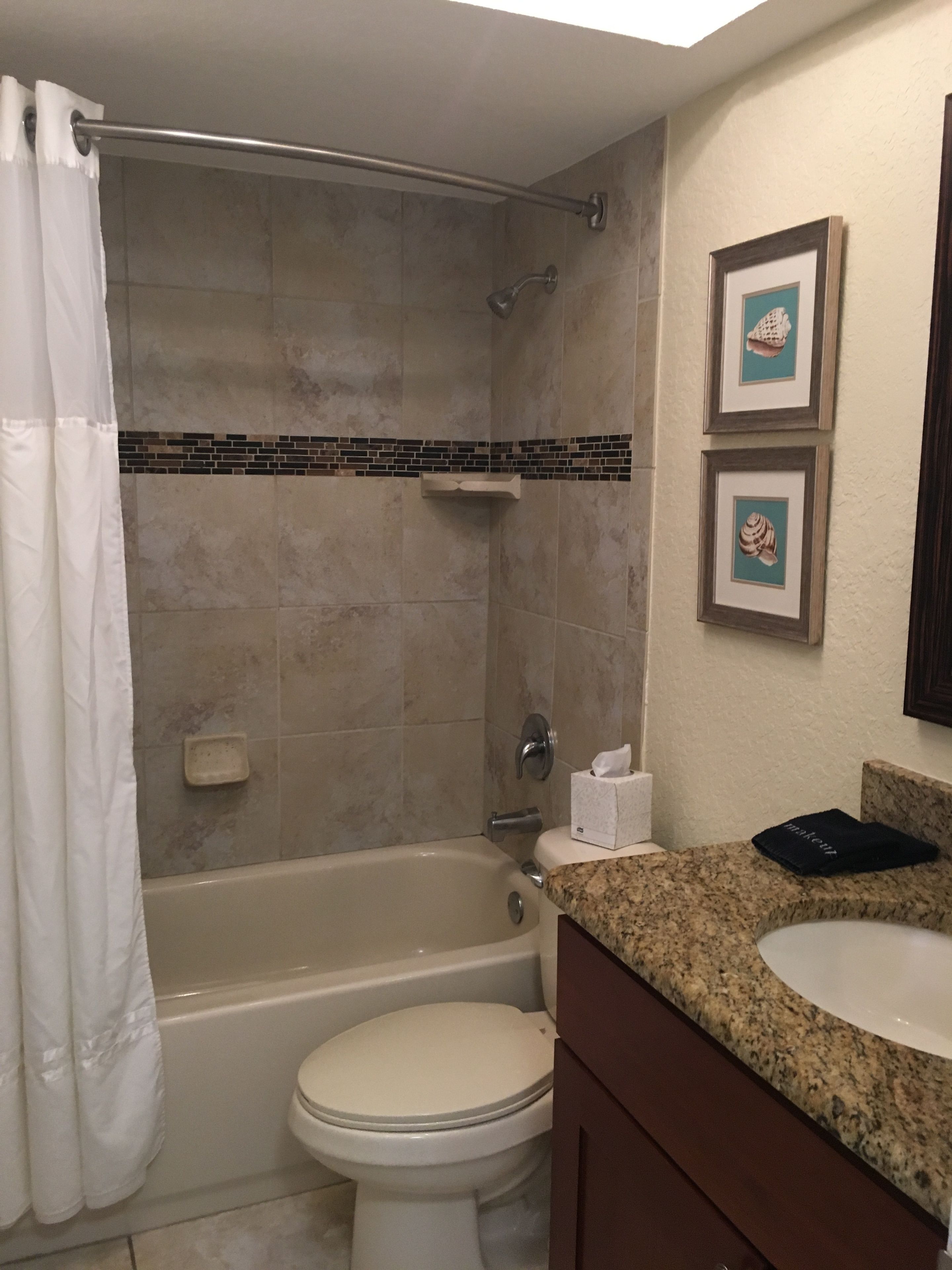A bathroom with a bathtub, toilet, and sink.