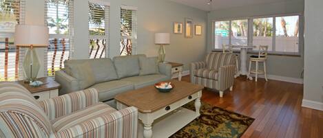 A living room with a sofa, chairs, a coffee table, and a ceiling fan.