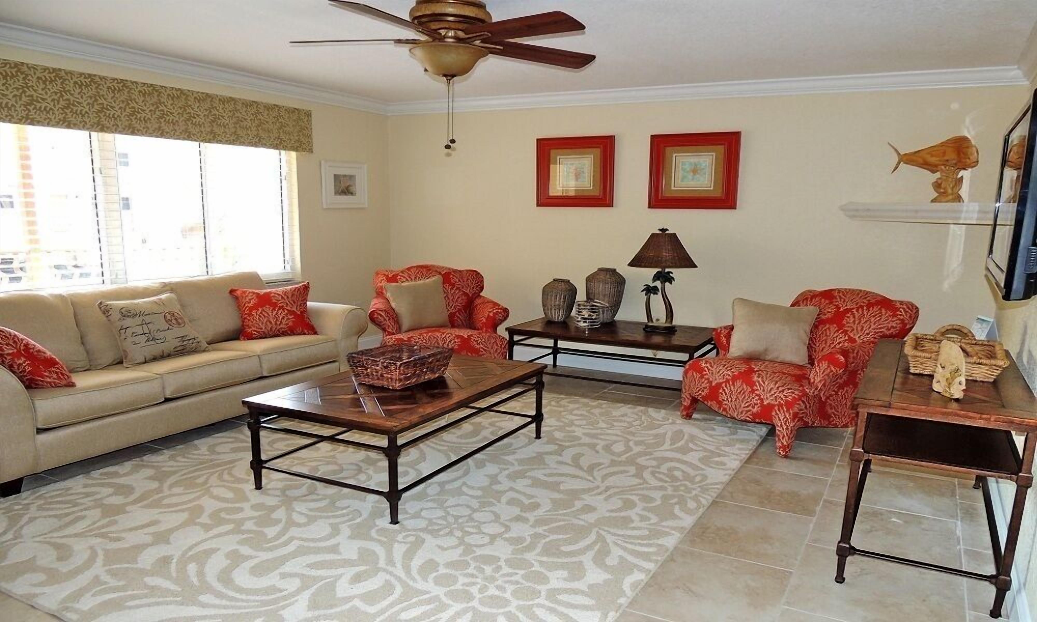 A living room with a sofa, armchairs, a coffee table, and a TV.