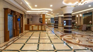 A spacious lobby with a marble floor, a reception desk, and a staircase. - Bristol Hotel (Amman)