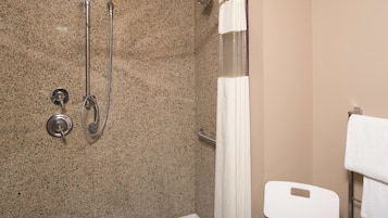 A bathroom with a shower, a toilet, and a towel rack.