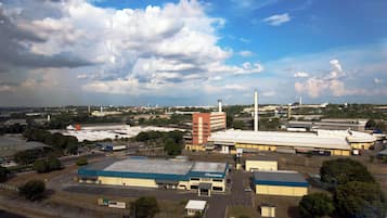 An industrial area with large buildings, a parking lot, and a clear sky.
