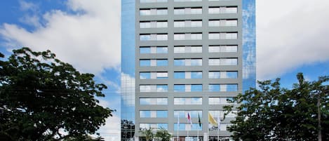 Un moderno edificio de hotel con fachada curva, múltiples ventanas y un letrero de Holiday Inn.