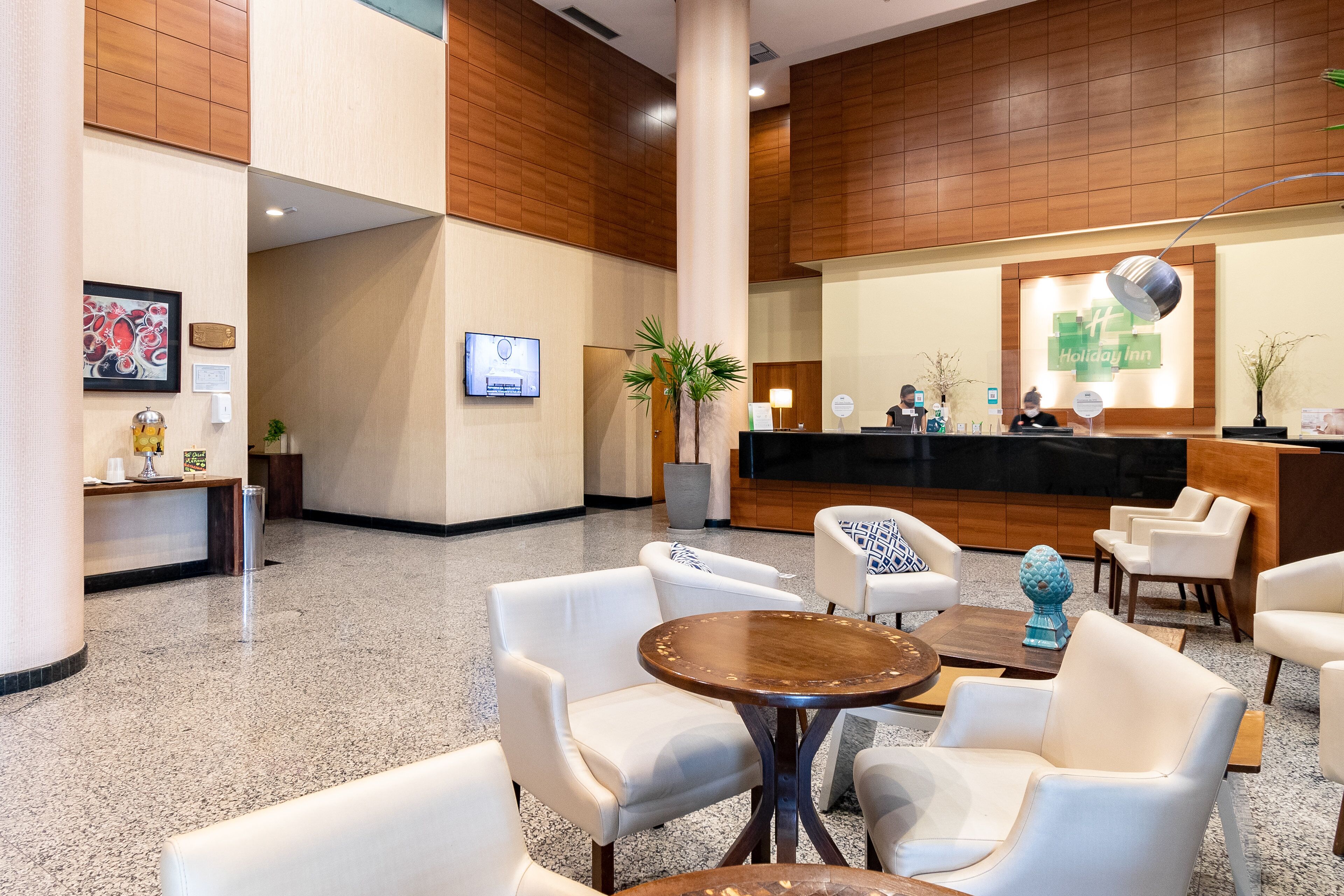 A lobby with a reception desk, seating area, and a large column.