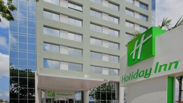 Edificio de hotel Holiday Inn con fachada moderna, ventanas amplias y un logotipo verde destacado.