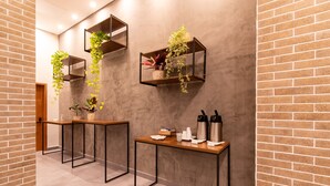 Un interior moderno con paredes de ladrillo, dos mesas con estructura de metal negro y estantes colgantes con plantas.