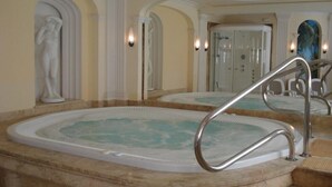 A spa area with a large hot tub, marble steps, and classical architectural elements like columns and arches. - Hotel Polaris (Swinoujscie)