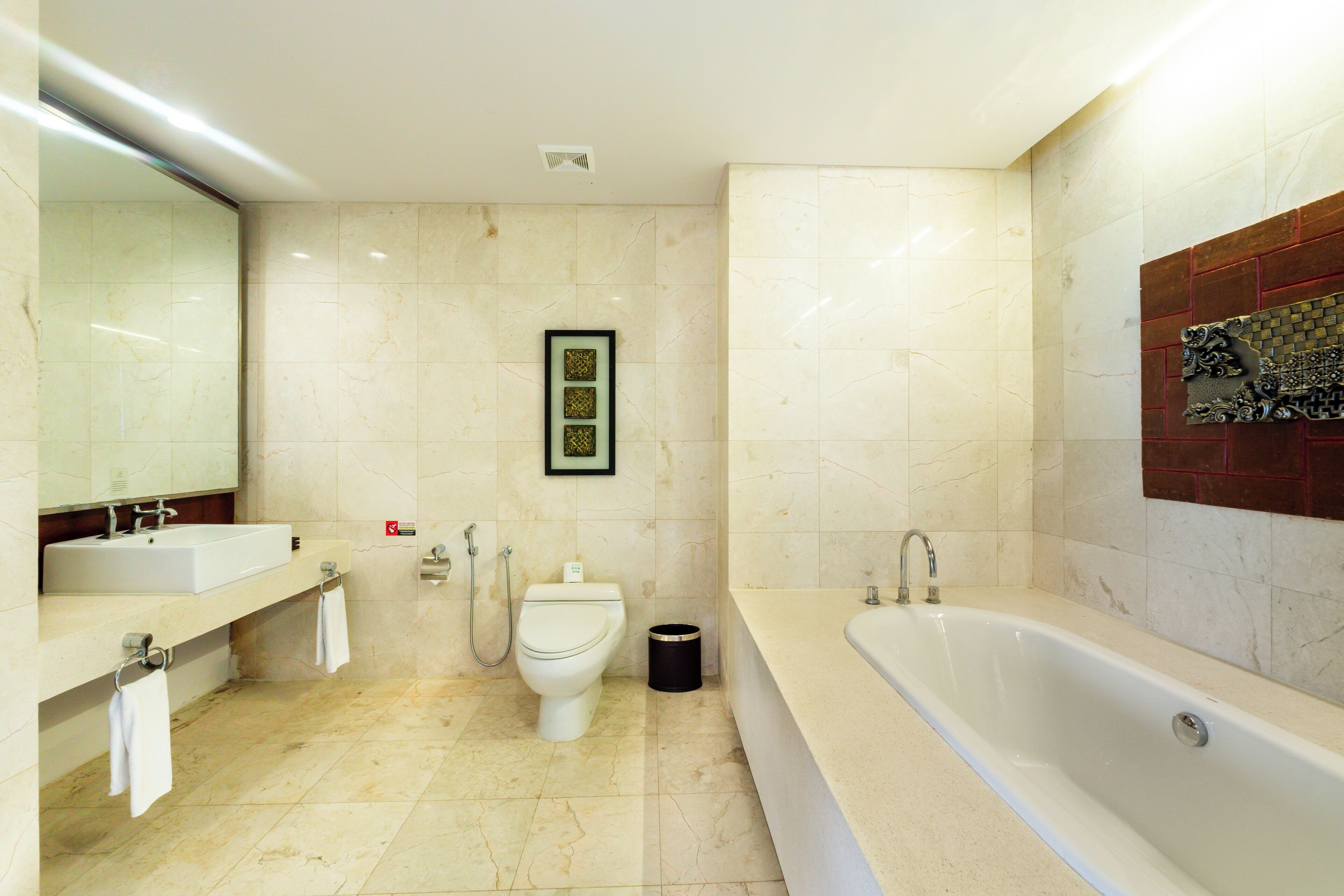 Een moderne badkamer met een groot bad, een wastafel en een toilet.