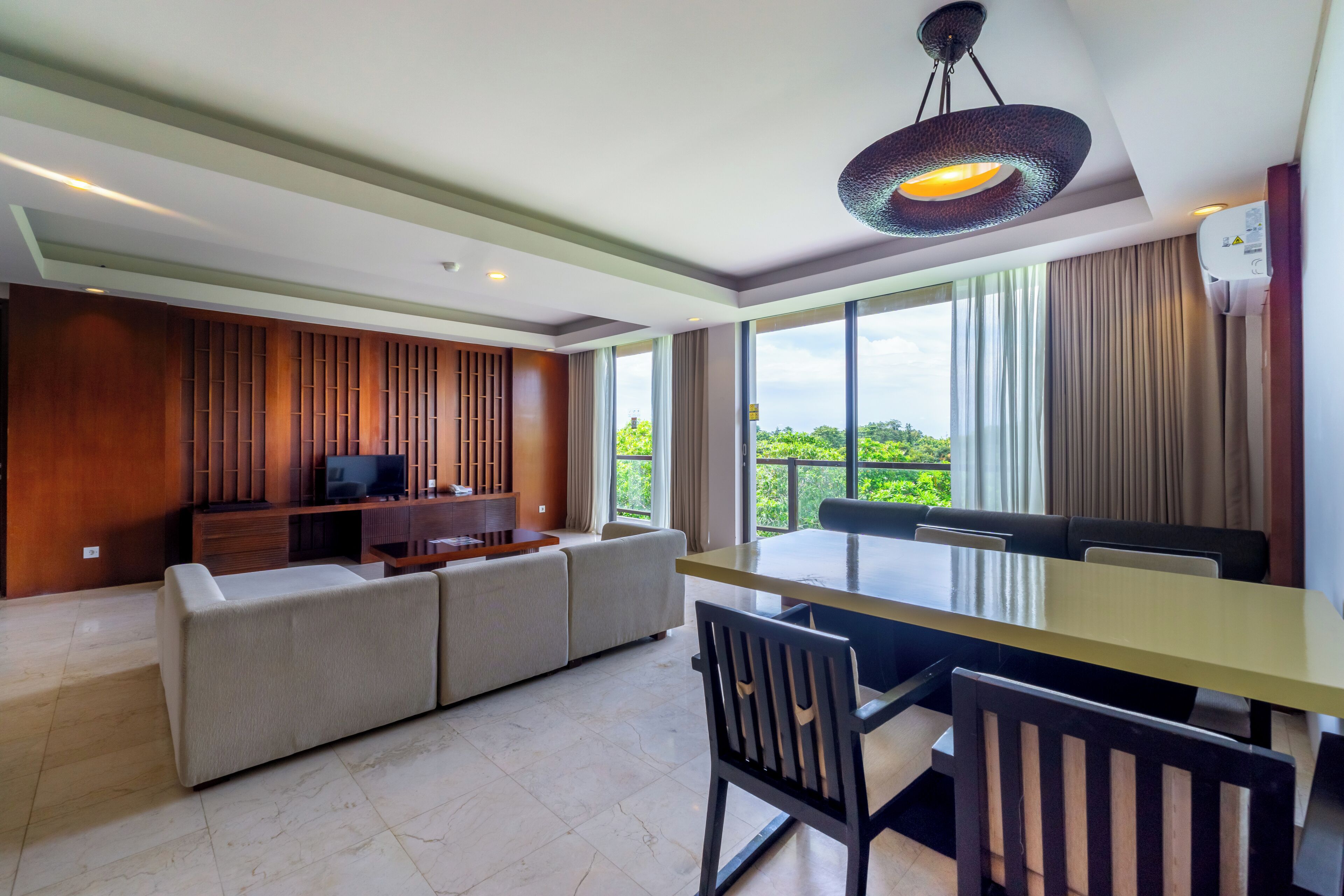 A modern living room with a sofa, TV, and dining area.