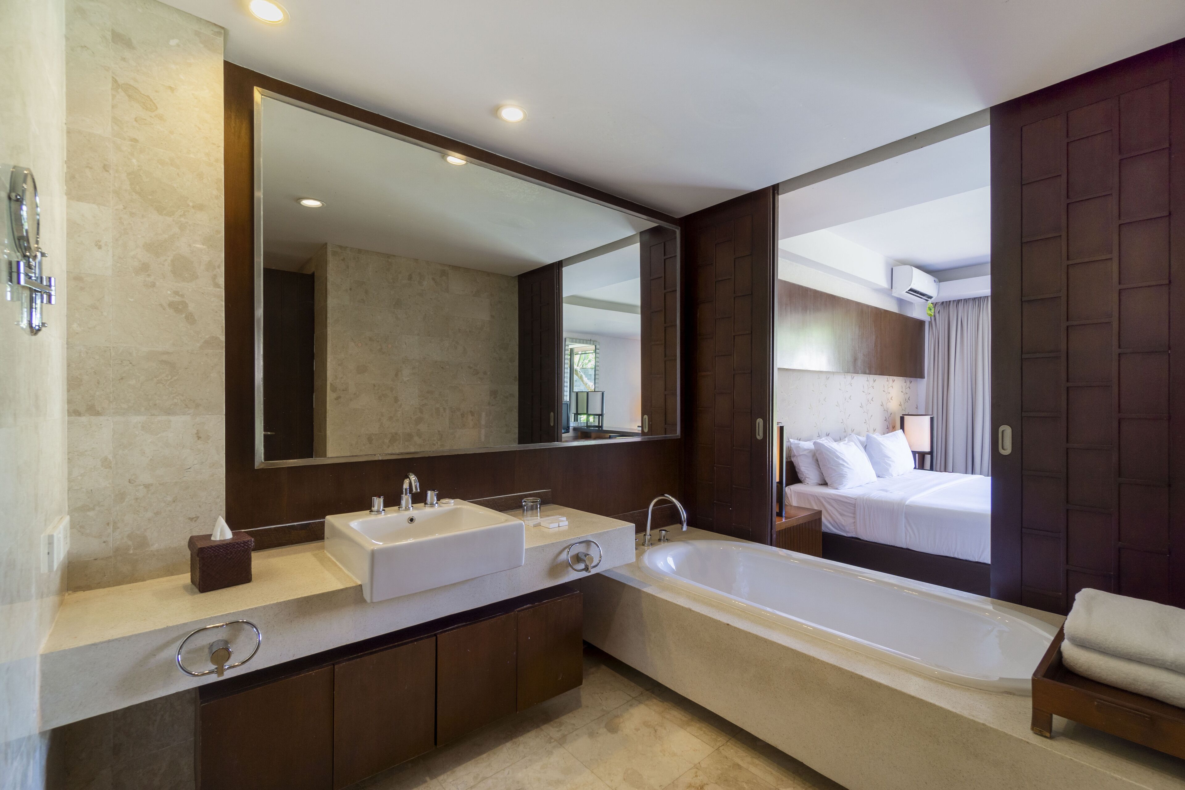 Un baño moderno con una bañera grande, dos lavamanos y un espejo amplio.