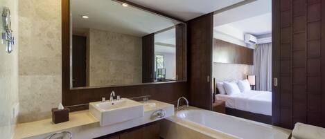 Un baño moderno con una bañera grande, dos lavamanos y un espejo amplio.