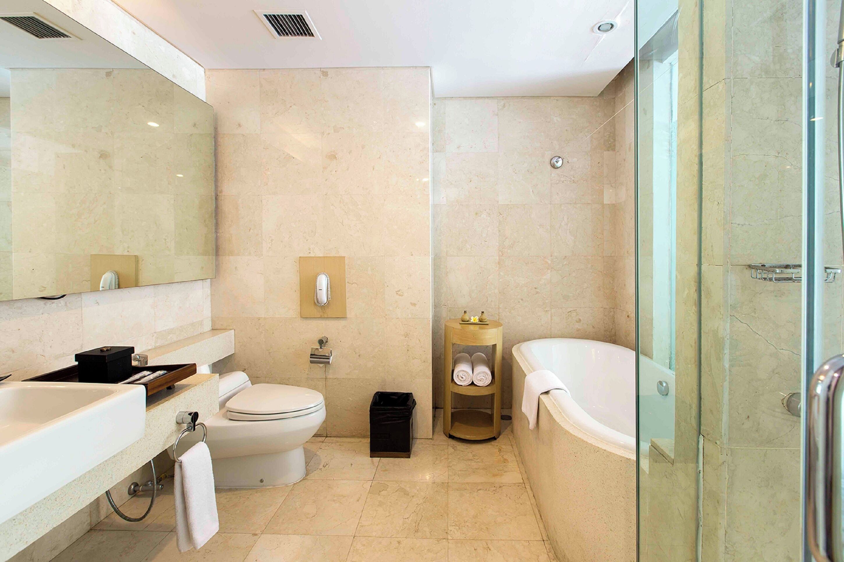 Un baño moderno con lavamanos, inodoro y bañera blancos.