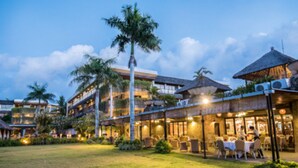 A hotel with multiple dining areas, outdoor seating, and a well-lit courtyard.