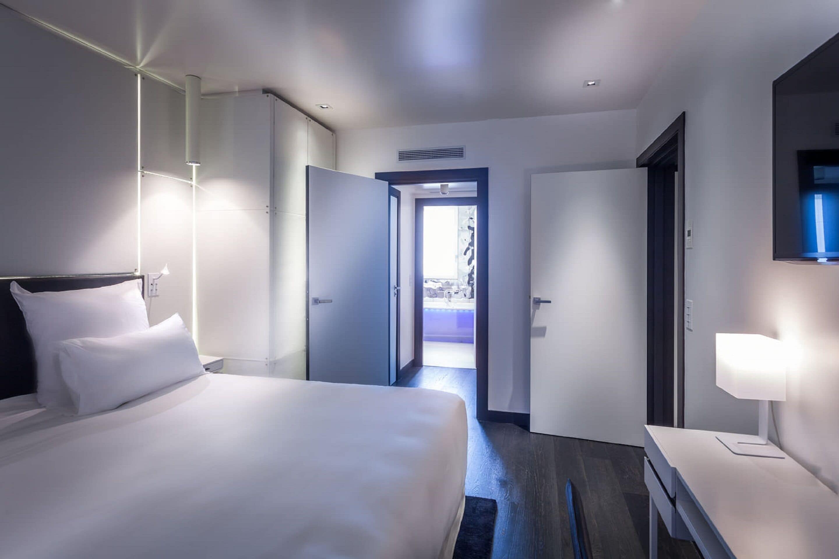 Een moderne hotelkamer met een groot bed, een bureau en een televisie.