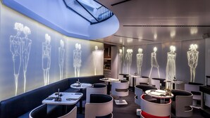 Un restaurant moderne doté d’œuvres d’art originales sur les murs, de mobilier contemporain et d’une verrière.