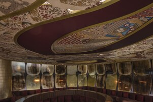 A theater with ornate ceiling designs and a circular seating arrangement.
