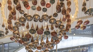 Een modern interieur met een glazen doorgang en hangende decoratieve elementen.