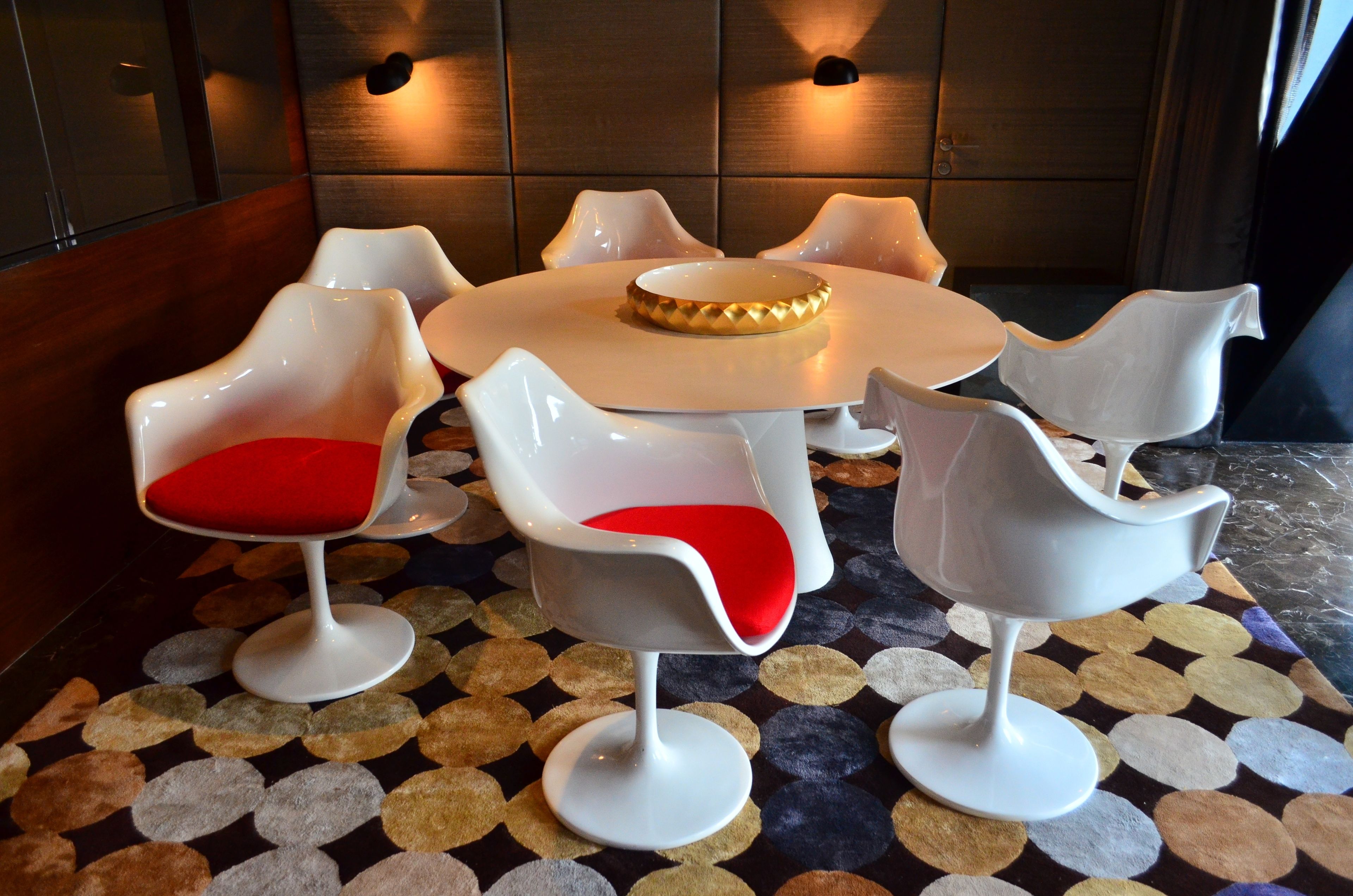 Un comedor moderno con una mesa redonda y seis sillas de diseño único.