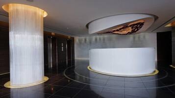 Experience the sleek, modern lobby with a cylindrical column, curved wall, and polished floor.