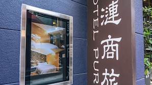 A hotel sign with Chinese characters and a window displaying a room interior. - Hotel Puri Ximen Branch (Taipei)