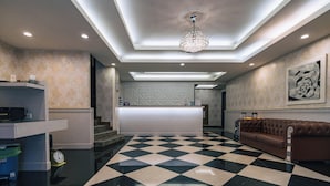 A lobby with a checkered floor, a reception desk, a brown sofa, and a chandelier. - Hotel Puri Ximen Branch (Taipei)