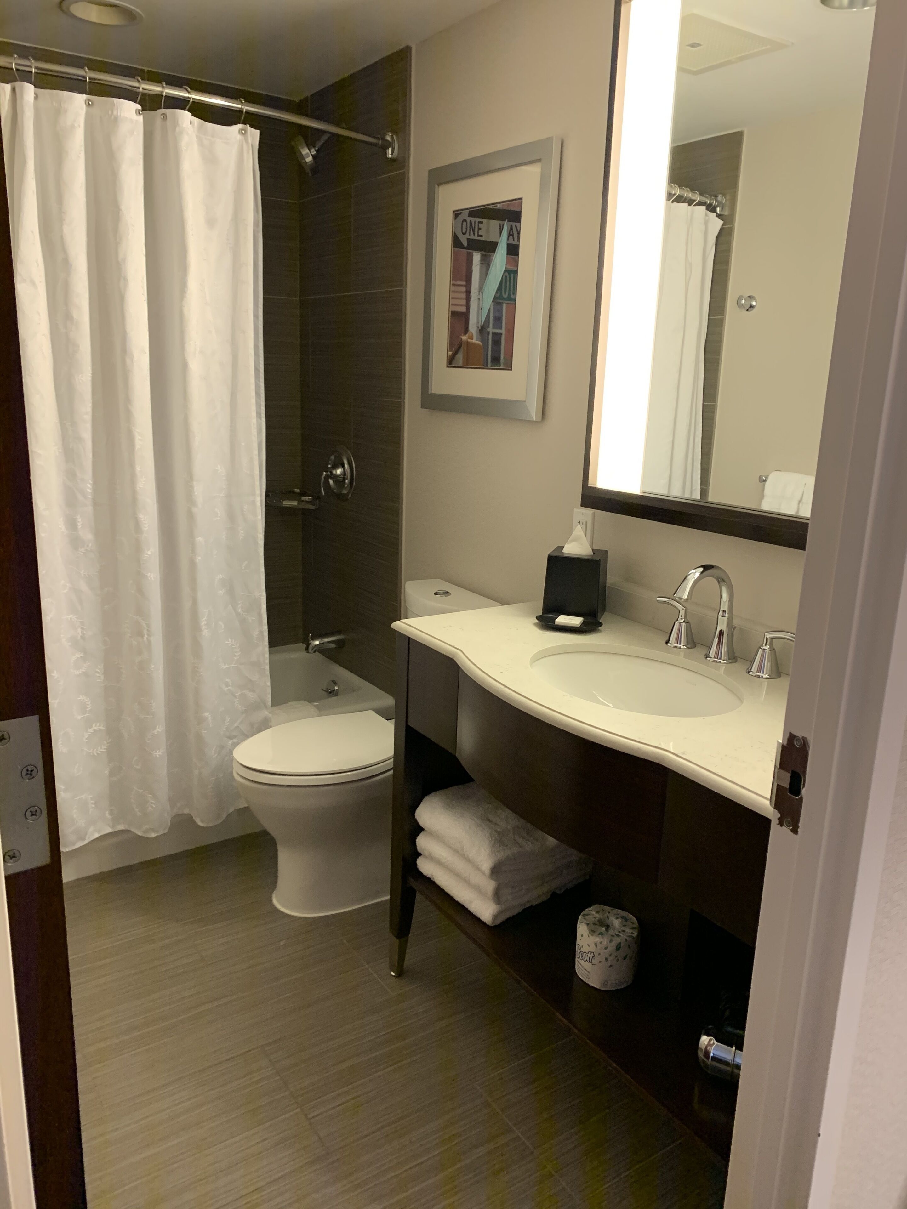 Un baño moderno con inodoro, lavamanos y cortina de ducha.