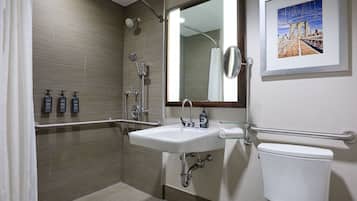 A modern bathroom with a shower, sink, and toilet.
