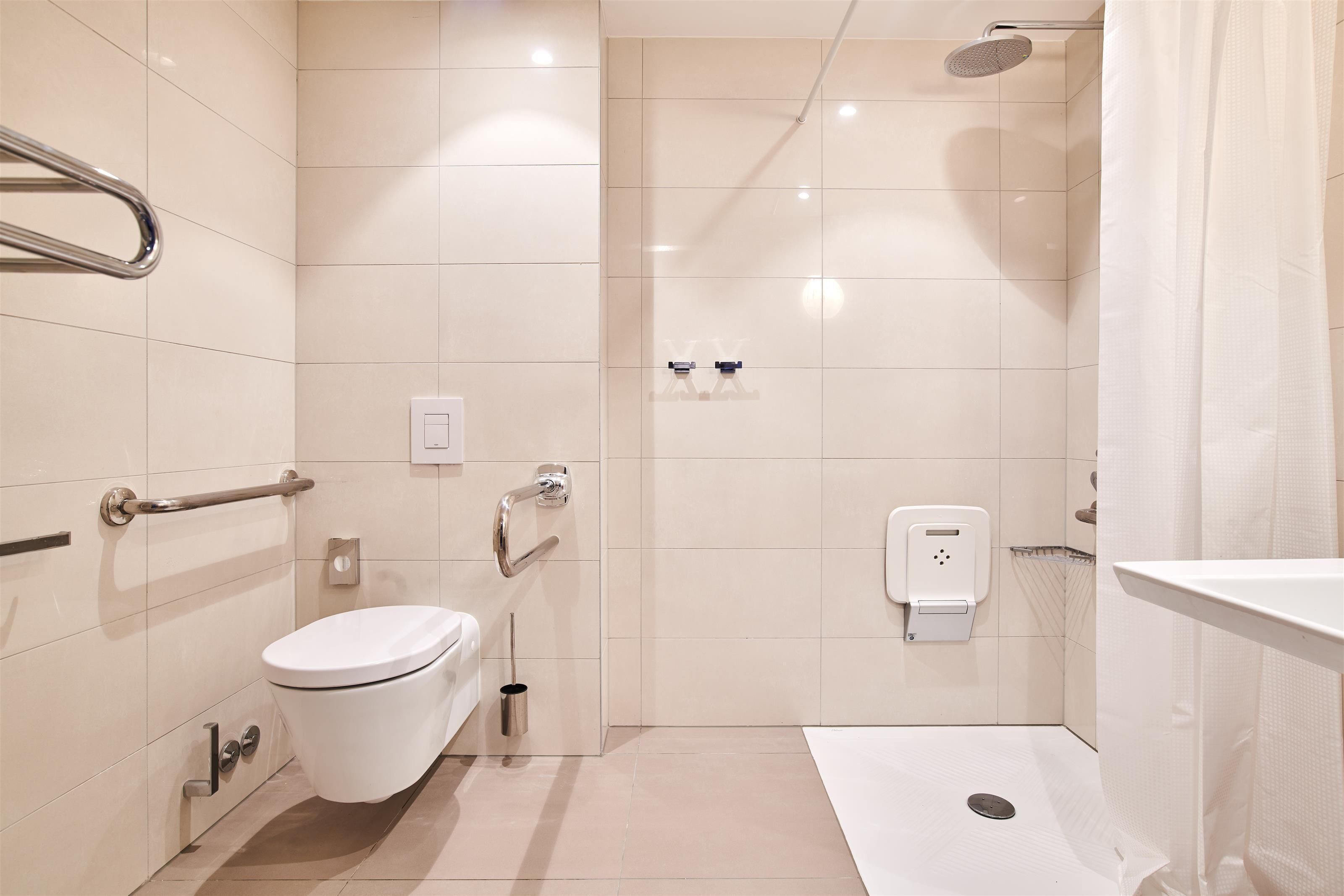 A modern bathroom with a toilet, bidet, and shower.